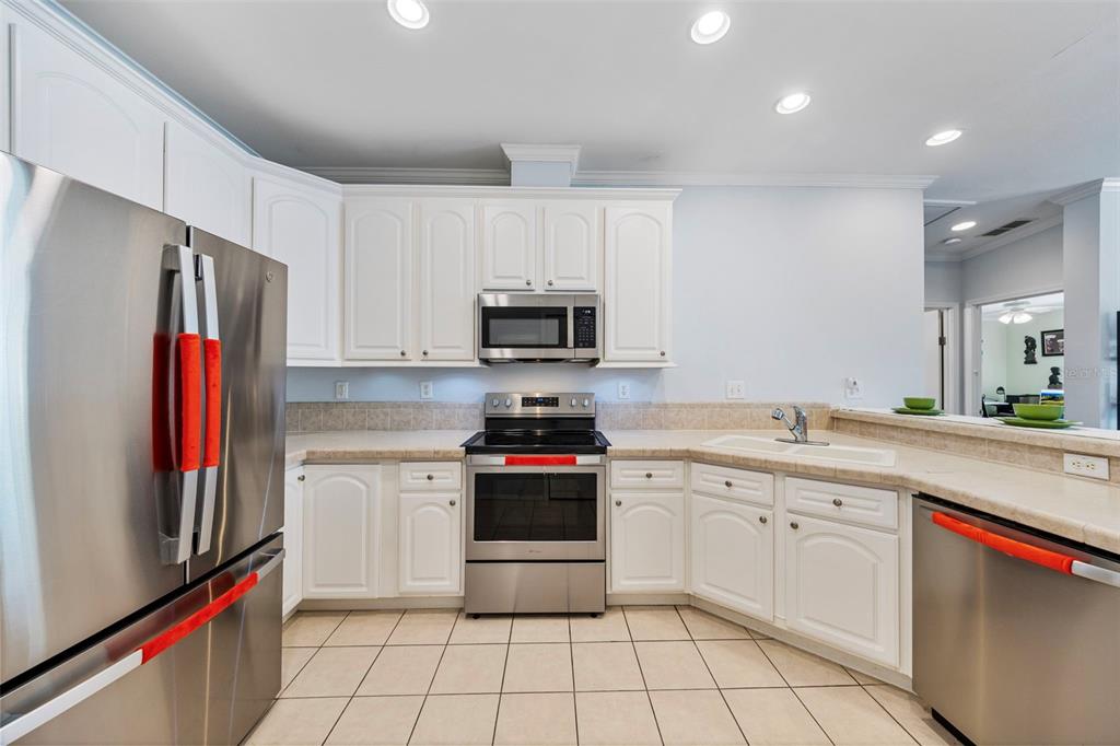 7641 Sailwinds Pass Port Richey, FL 34668 - Photo 14 of 59 a kitchen with stainless steel appliances granite countertop a refrigerator and a stove top oven