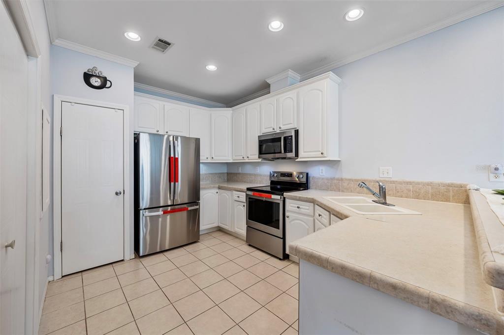 7641 Sailwinds Pass Port Richey, FL 34668 - Photo 16 of 59 a kitchen with a refrigerator and a sink