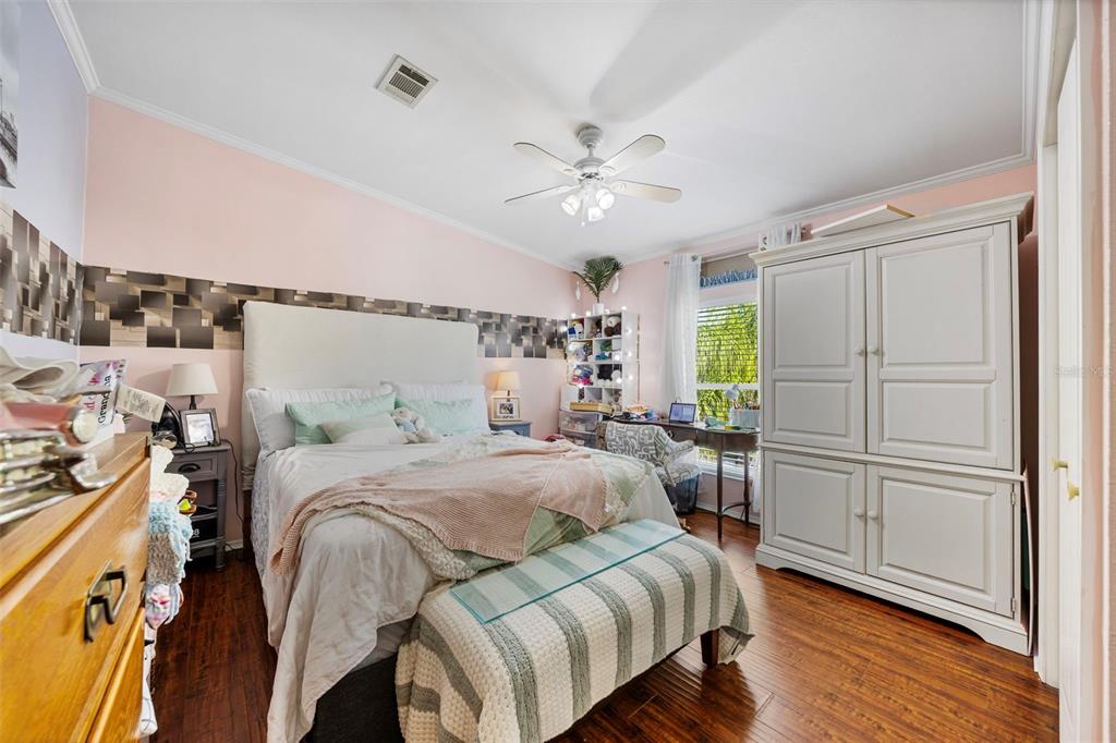 7641 Sailwinds Pass Port Richey, FL 34668 - Photo 19 of 59 a bedroom with a bed and a chandelier