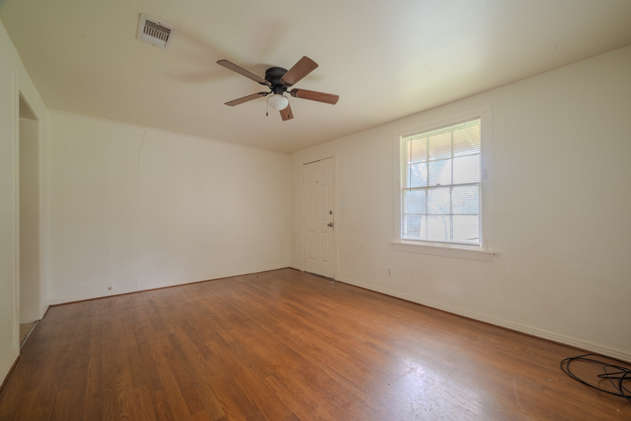 1005 Center Street Wharton, TX 77488 - Photo 9 of 33 wooden floor in an empty room with a window
