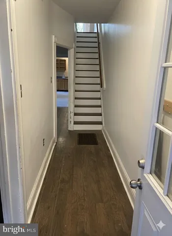 a view of a hallway with entryway and stairs