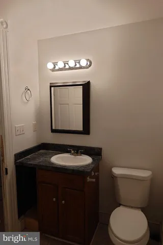 a bathroom with a granite countertop toilet sink and mirror