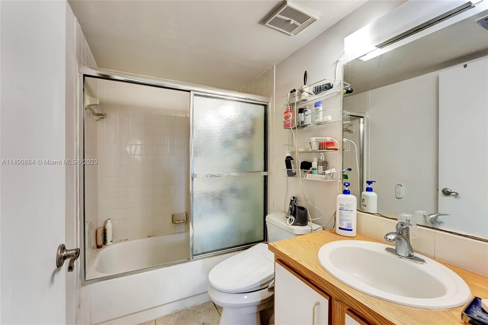 677 Trace Circle, Unit 210 Deerfield Beach, FL 33441 - Photo 14 of 21 a bathroom with a sink a toilet and a large mirror