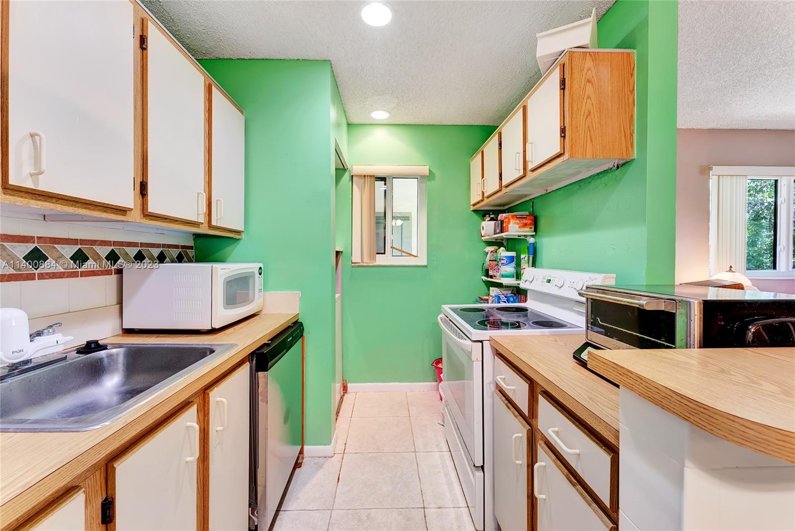 677 Trace Circle, Unit 210 Deerfield Beach, FL 33441 - Photo 5 of 21 a kitchen that has a sink and a stove