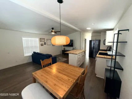 a living room with furniture a flat screen tv and kitchen view
