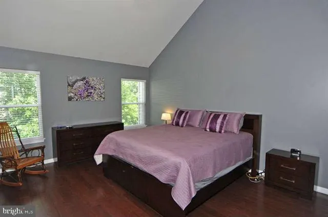 a bedroom with a bed and a dresser next to a window