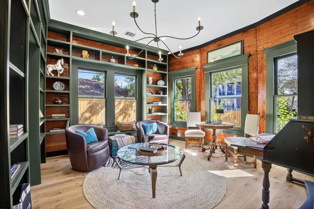a living room with furniture a fireplace and large windows