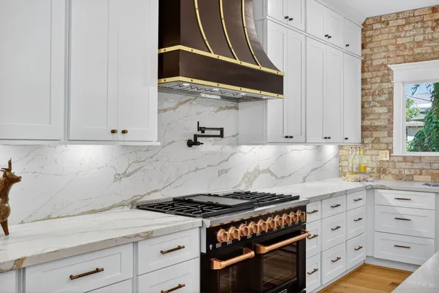 a kitchen with granite countertop a stove and a white cabinet