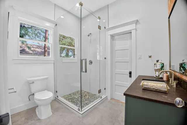a bathroom with a granite countertop sink a toilet and shower