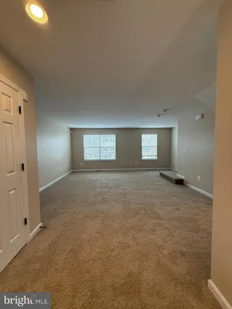 a white toilet sitting next to a white wall