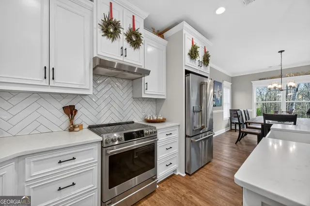 a kitchen with stainless steel appliances granite countertop a stove and a refrigerator