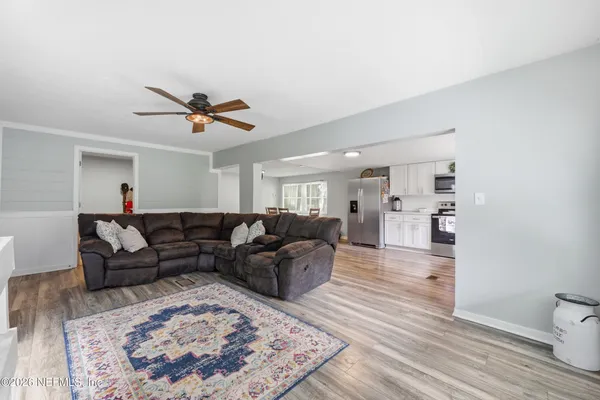 a living room with furniture and a wooden floor