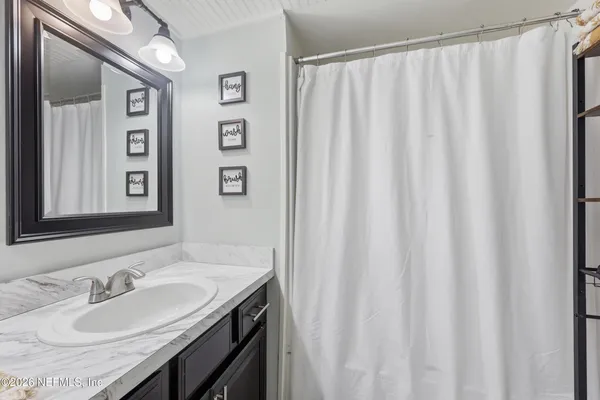 a bathroom with a granite countertop sink and a mirror