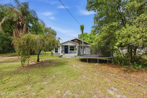 a backyard of a house with table and chairs