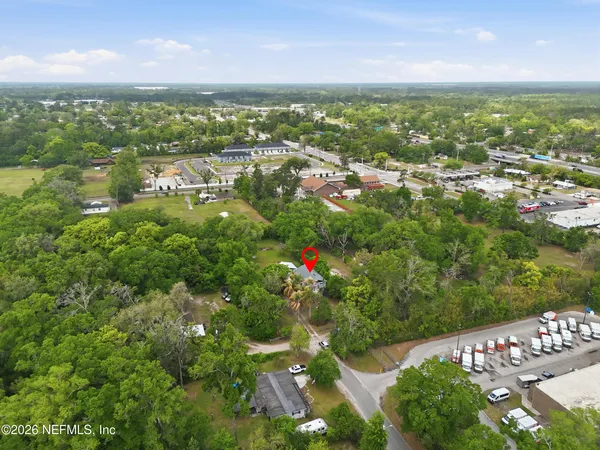 an aerial view of residential houses with outdoor space and trees