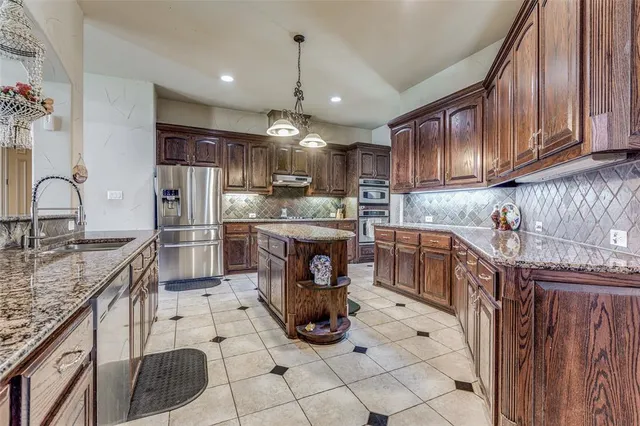 a kitchen with stainless steel appliances granite countertop a sink stove and refrigerator
