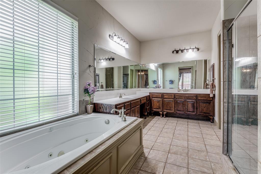 2245 Homestead Lane Plano, TX 75025 - Photo 23 of 25 a bathroom with a tub a sink a mirror and a shower