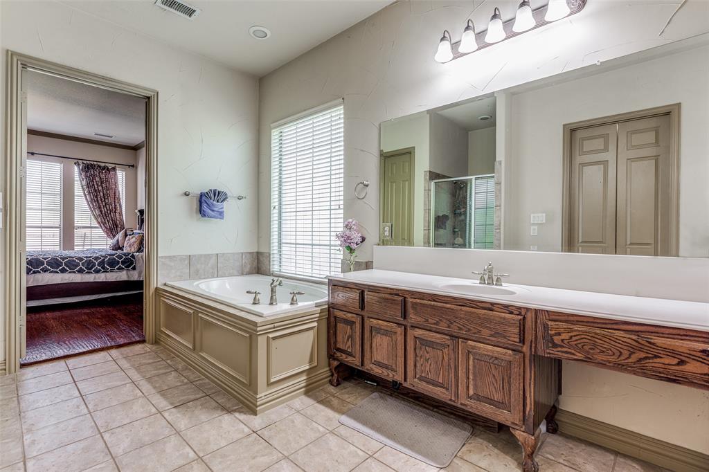 2245 Homestead Lane Plano, TX 75025 - Photo 24 of 25 a spacious bathroom with a double vanity sink a mirror and a bathtub