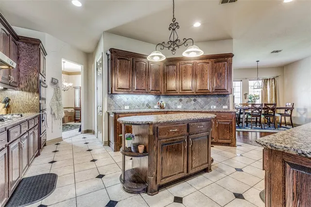 a kitchen with stainless steel appliances granite countertop a stove a sink a counter space and cabinets