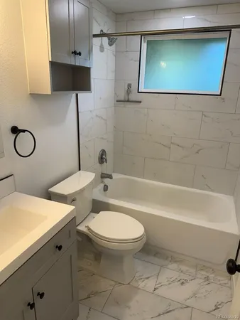a bathroom with a sink a toilet a mirror and shower