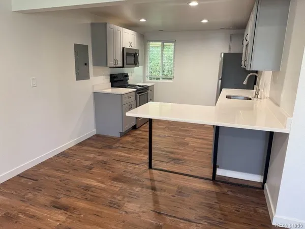 an empty room with wooden floor and entrance