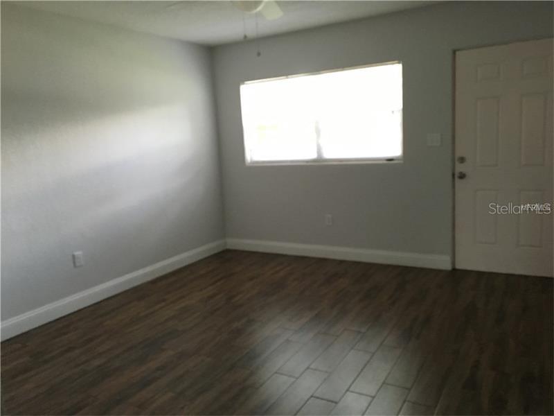 508 Varsity Street Winter Garden, FL 34787 - Photo 3 of 10 an empty room with wooden floor and windows