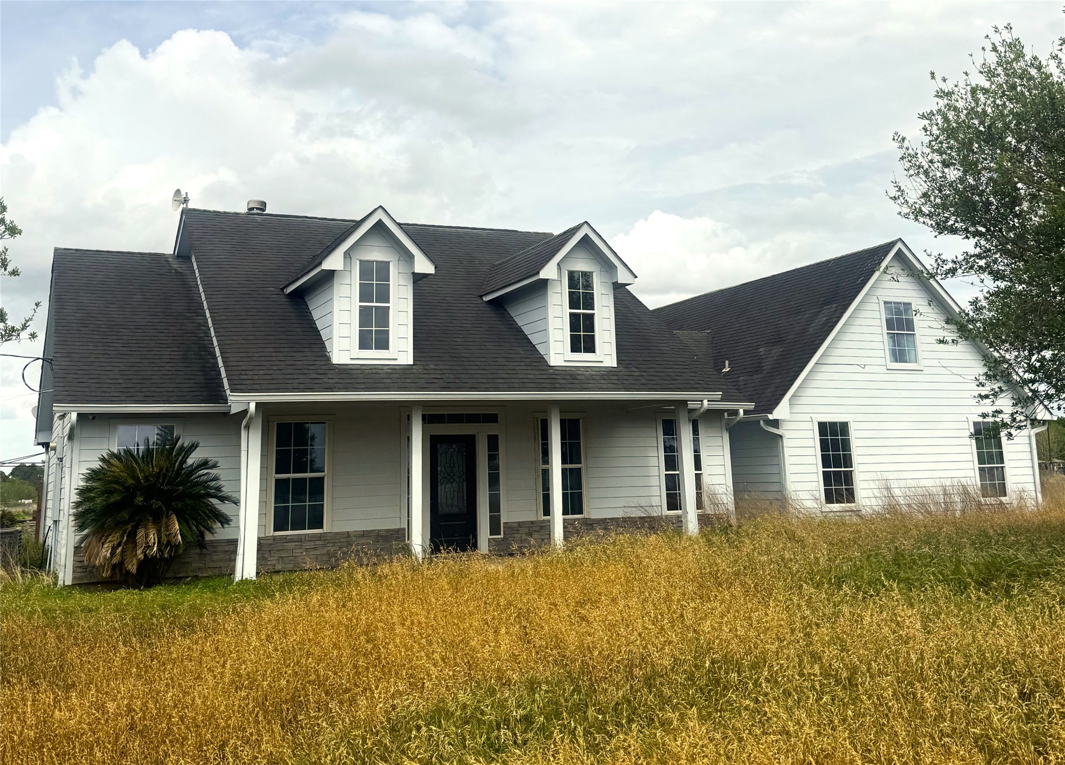 a front view of house with yard and trees around