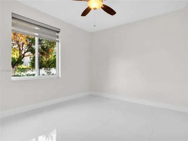 an empty room with a window and a ceiling fan