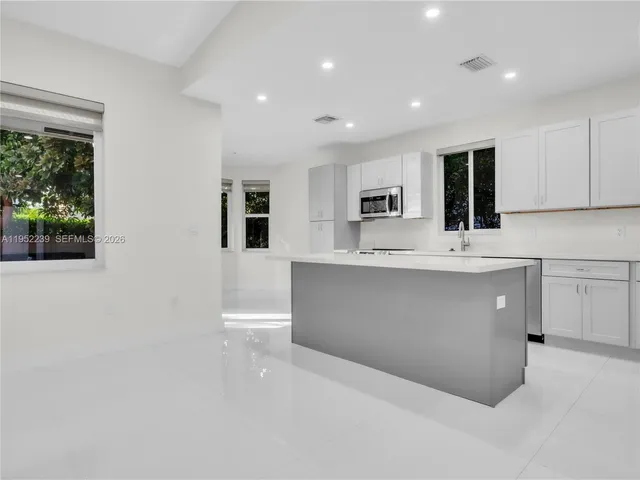 a view of kitchen with stainless steel appliances cabinets