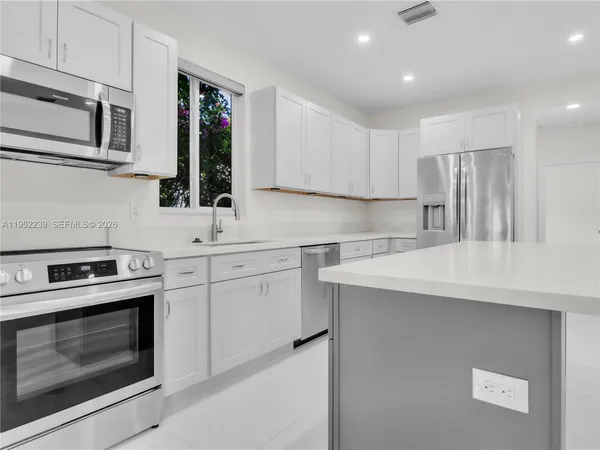 a kitchen with a sink stove and microwave