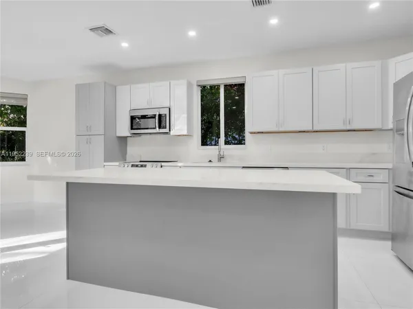 a kitchen with stainless steel appliances granite countertop a sink and a stove top oven