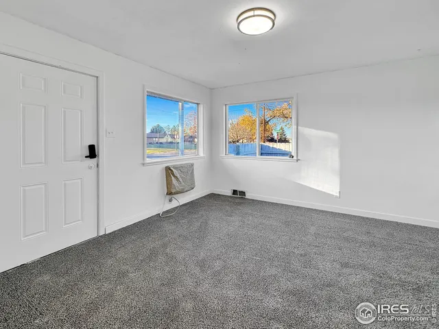 an empty room with windows and cabinet