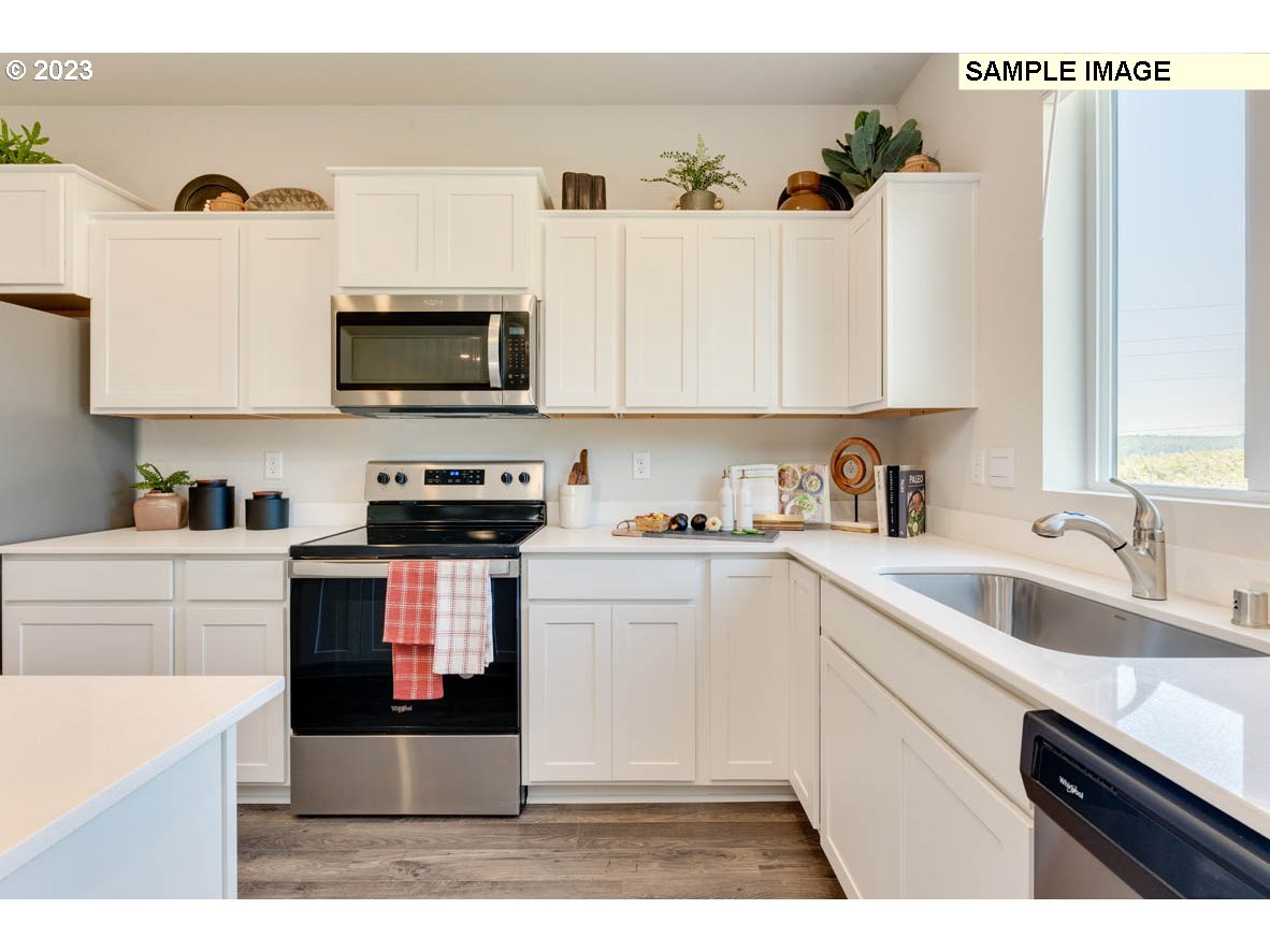 141 Cedar Springs Loop North Kalama, WA 98625 - Photo 11 of 31 a kitchen with white cabinets a sink and appliances
