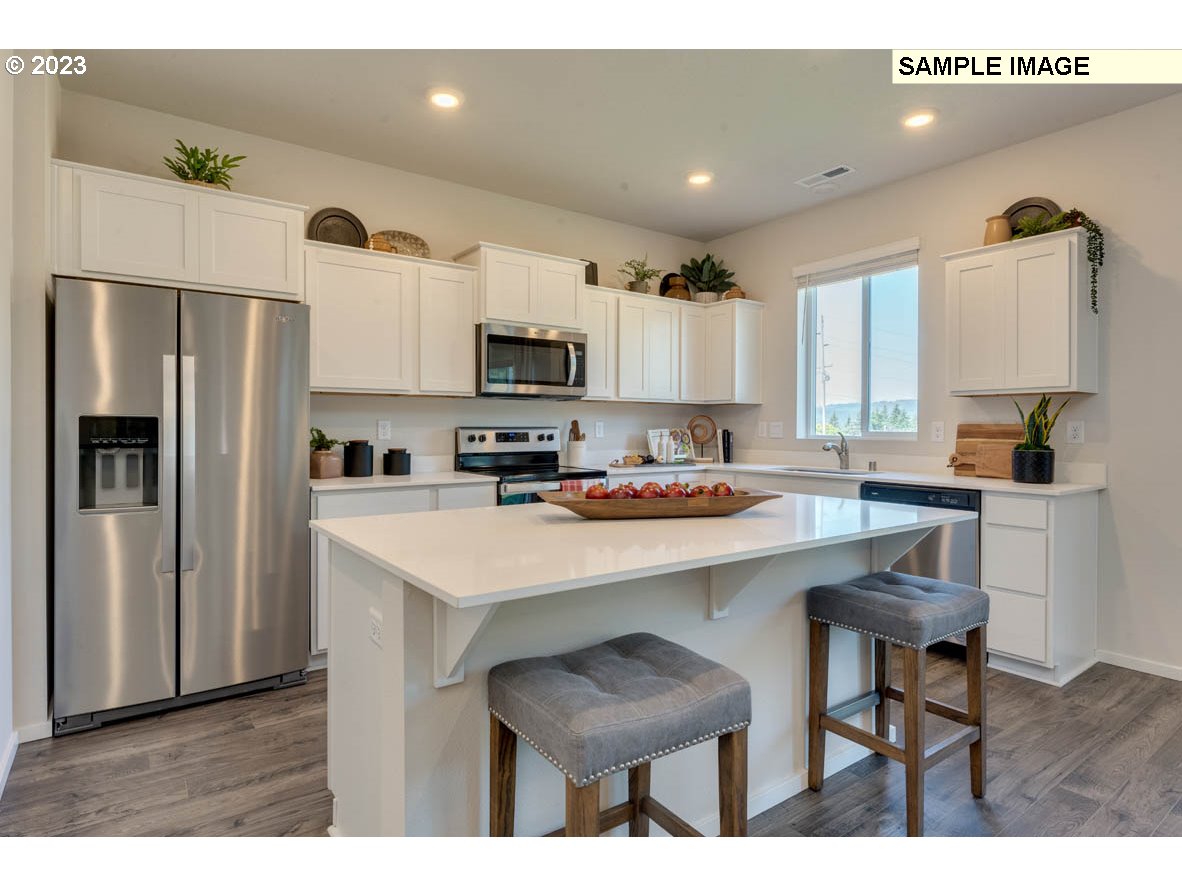 141 Cedar Springs Loop North Kalama, WA 98625 - Photo 10 of 31 a kitchen with kitchen island a refrigerator stove and microwave