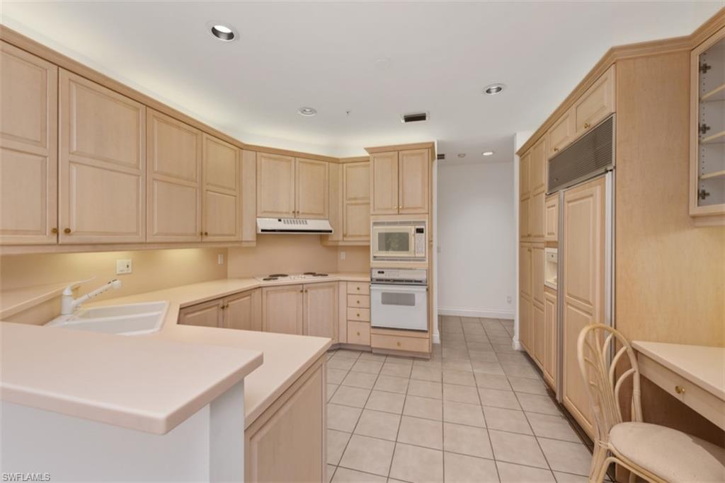 133 Colonade Circle Naples, FL 34103 - Photo 7 of 24 a kitchen with stainless steel appliances a refrigerator sink and cabinets