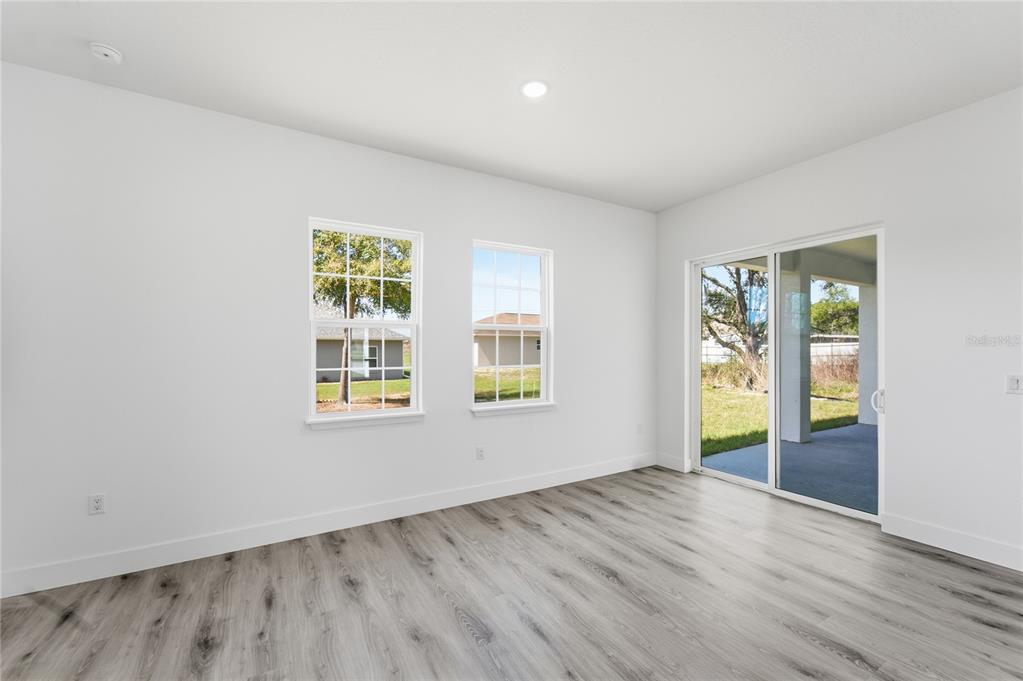 2600 Southwest 146th Pl Road Ocala, FL 34473 - Photo 14 of 40 an empty room with wooden floor and windows