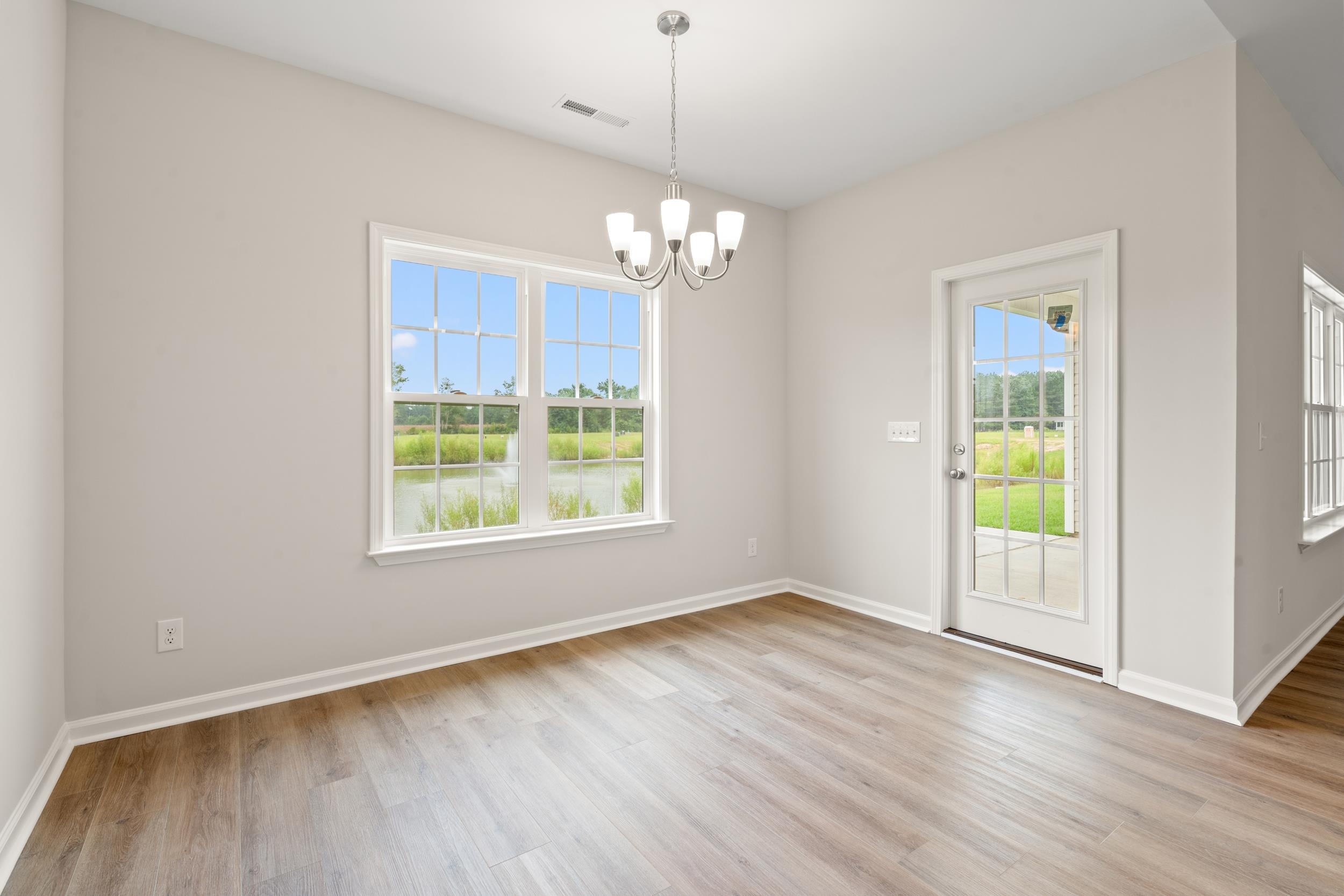 219 Stillbrook Drive Longs, SC 29568 - Photo 6 of 33 Unfurnished dining area with light wood-style flooring and a chandelier