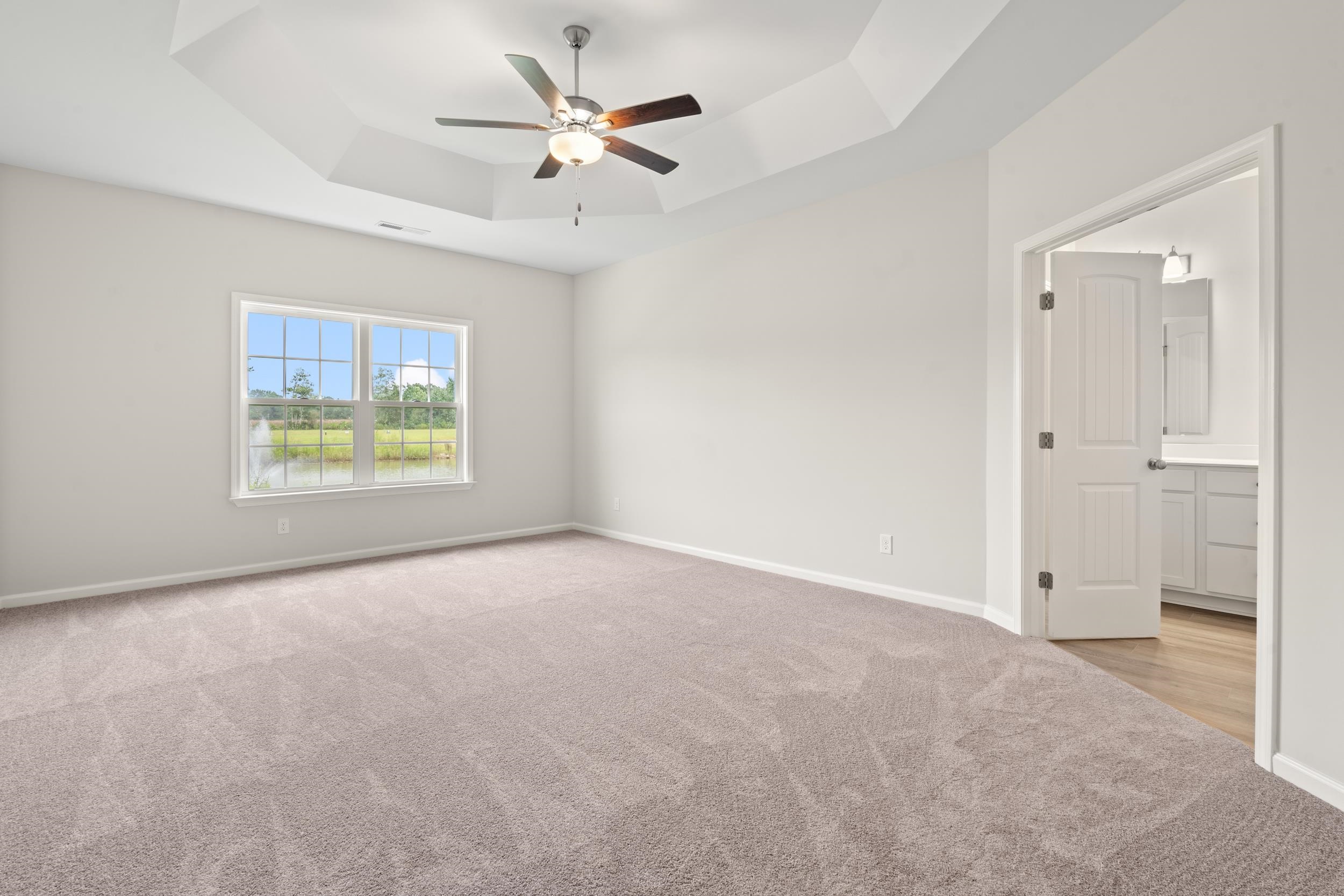 219 Stillbrook Drive Longs, SC 29568 - Photo 8 of 33 Empty room with light carpet, a tray ceiling, and ceiling fan