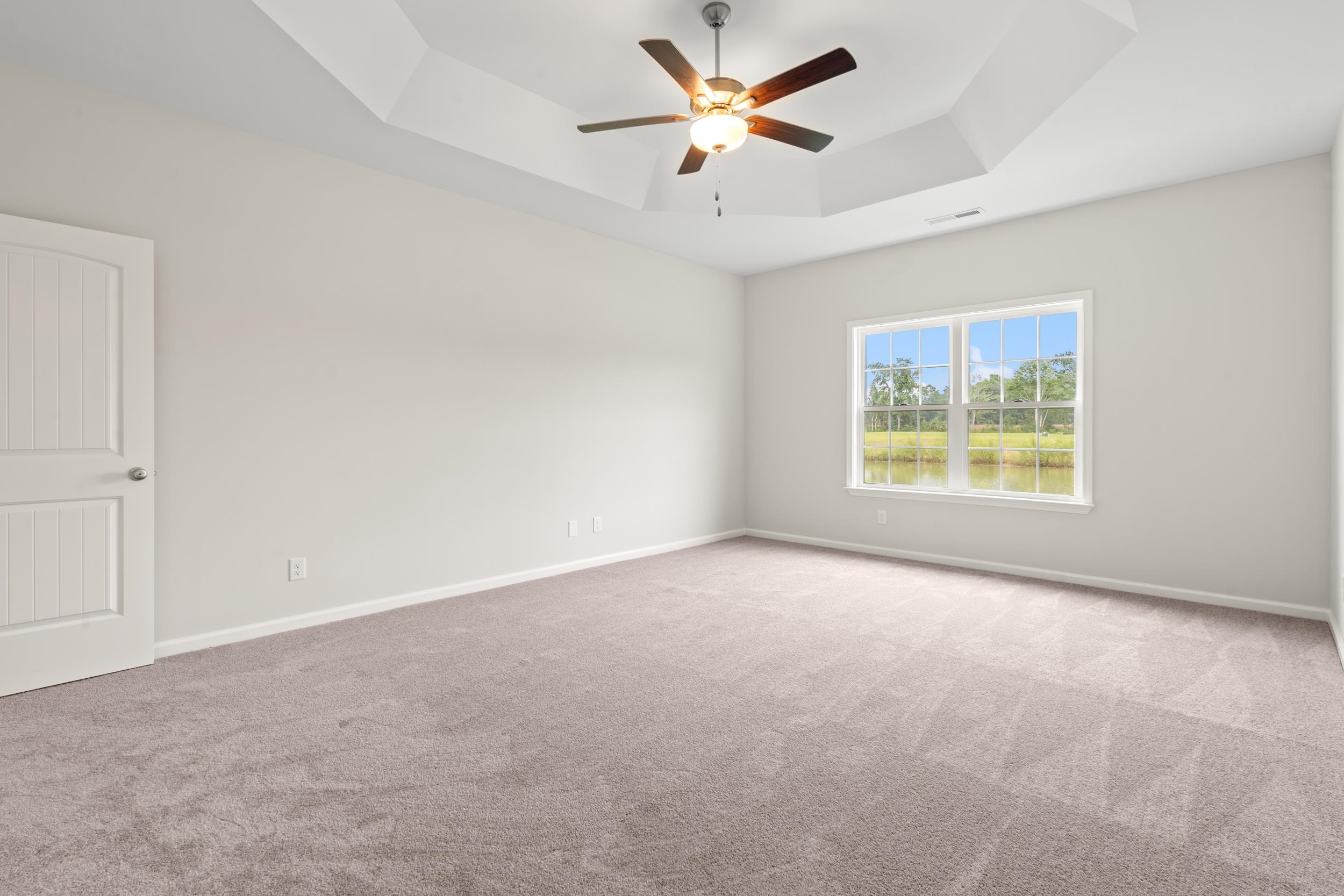 219 Stillbrook Drive Longs, SC 29568 - Photo 9 of 33 Empty room with carpet flooring, a tray ceiling, and a ceiling fan