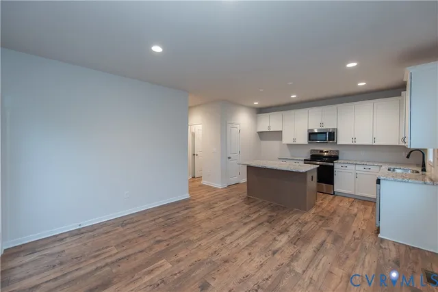 a large kitchen with stainless steel appliances granite countertop a stove a sink and a refrigerator