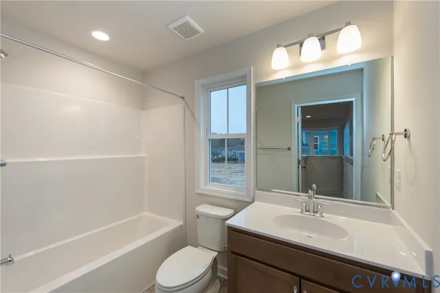 a bathroom with a sink a toilet a mirror and shower