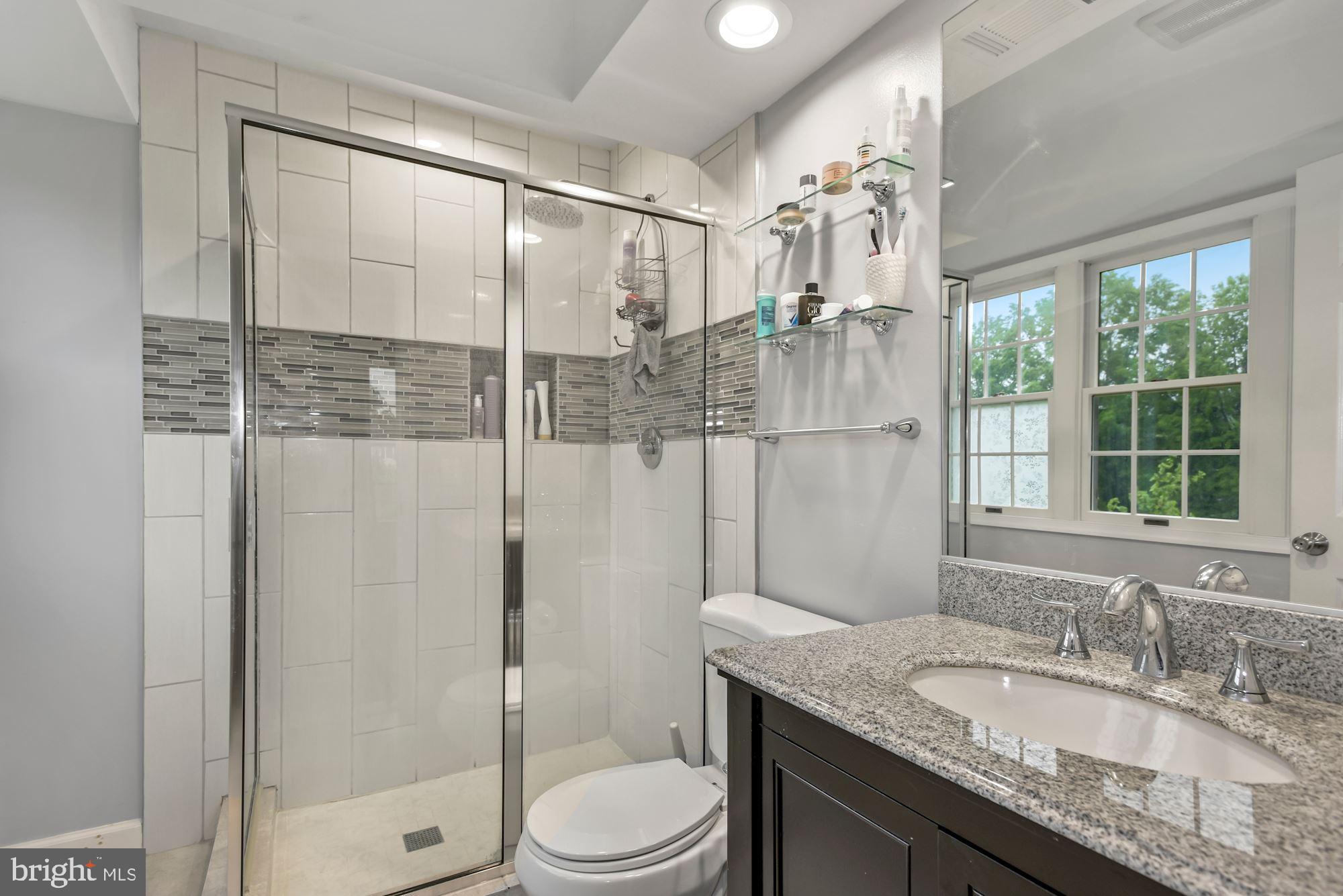 20121 Crew Square Ashburn, VA 20147 - Photo 23 of 36 a bathroom with a granite countertop sink toilet a mirror and shower