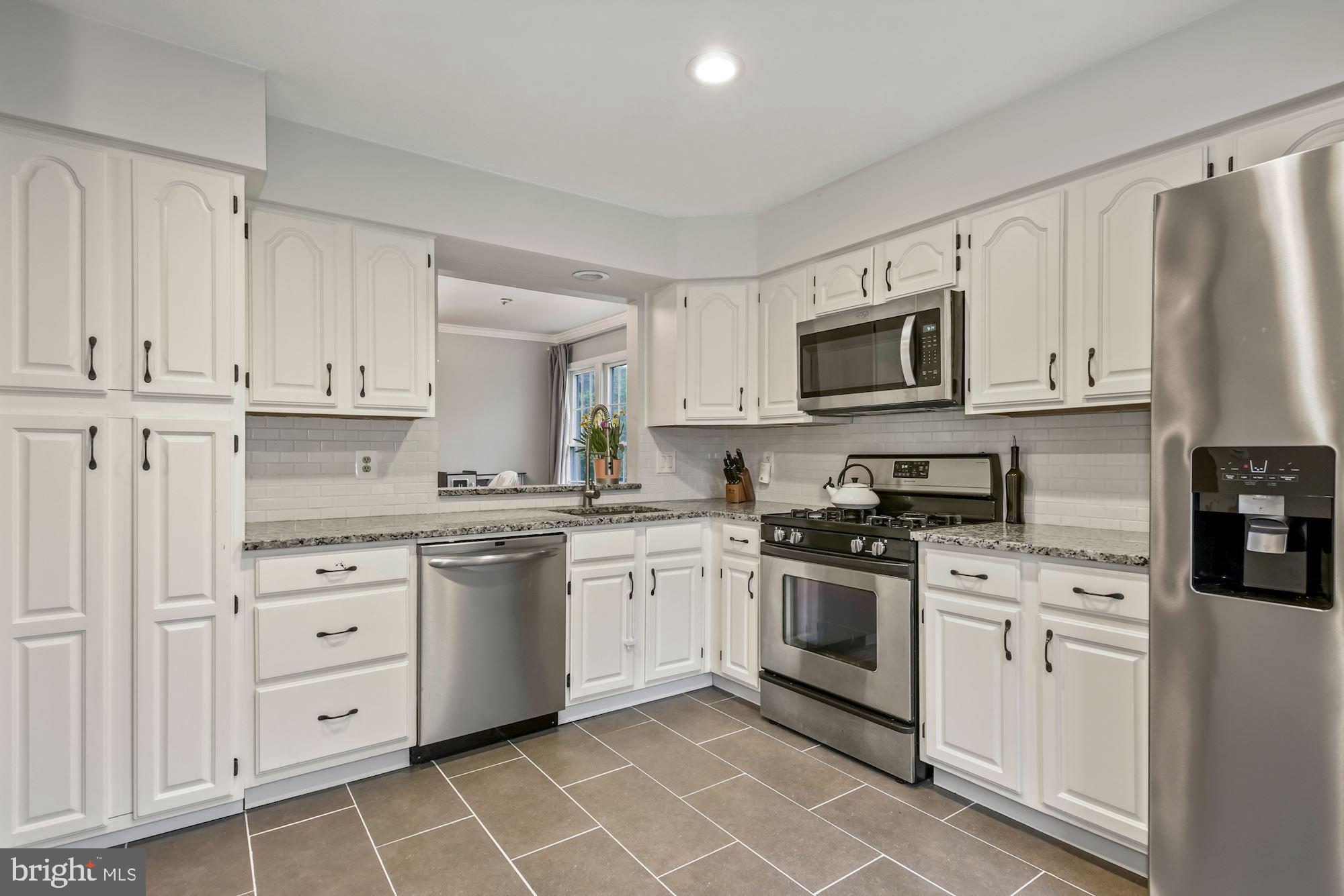 20121 Crew Square Ashburn, VA 20147 - Photo 8 of 36 a kitchen with white cabinets stainless steel appliances and a window