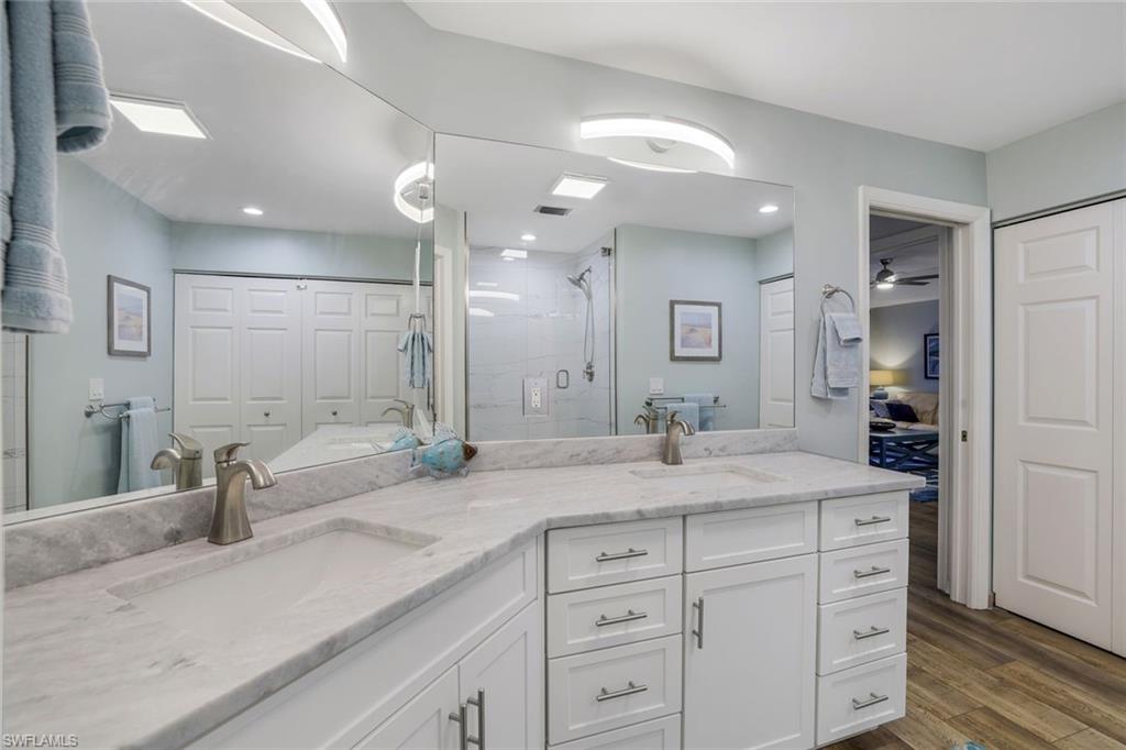 9101 Vanderbilt Drive, Unit 1302 Naples, FL 34108 - Photo 13 of 24 a spacious bathroom with a granite countertop sink mirror and shower