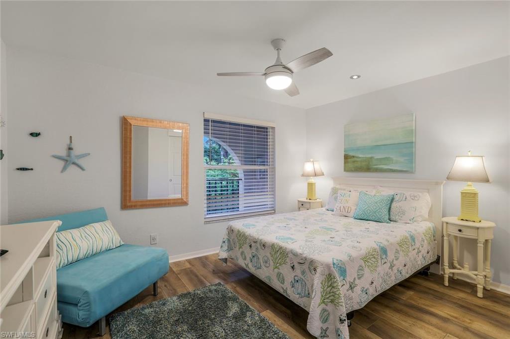 9101 Vanderbilt Drive, Unit 1302 Naples, FL 34108 - Photo 15 of 24 a bedroom with a bed and a couch