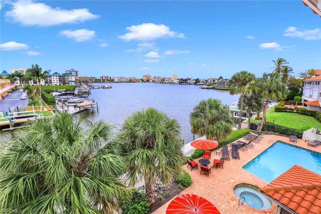 9101 Vanderbilt Drive, Unit 1302 Naples, FL 34108 - Photo 18 of 24 a view of a lake with couches and city view