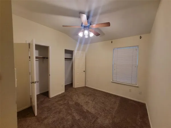 a view of a brick house with a big yard large tree and a large window