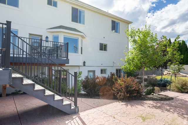 868 Braddock Lane Alpine, UT 84004 - Photo 58 of 64 Rear exterior featuring a composite deck with metal railings and stairs, a bay window, and a stamped concrete patio