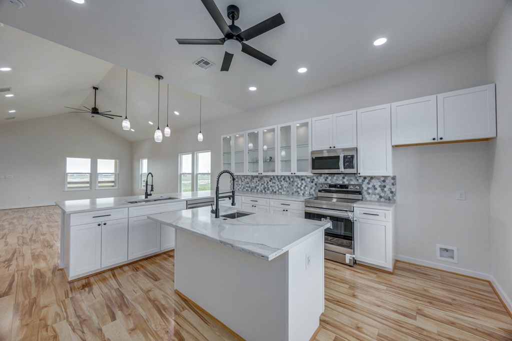 13-14 Bayview Loop Rockport, TX 78382 - Photo 11 of 26 a kitchen with stainless steel appliances granite countertop a sink a stove a refrigerator and island with wooden floor