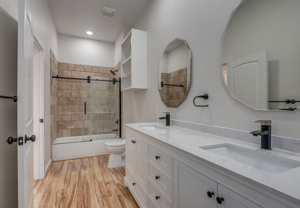 13-14 Bayview Loop Rockport, TX 78382 - Photo 14 of 26 a bathroom with a double vanity sink a toilet and a mirror